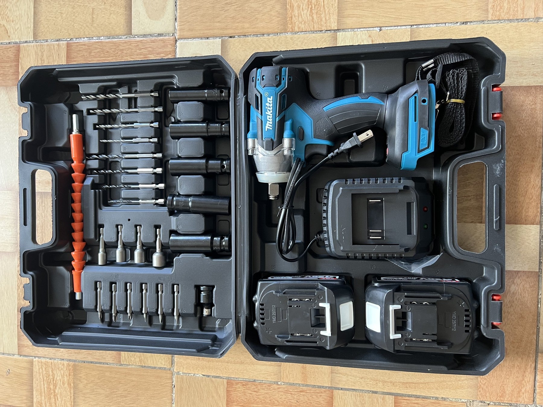 Foto real del kit tipo Makita abierto con dos baterías, cargador y accesorios