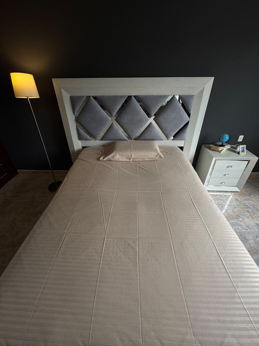 Foto real del juego en color beige, tendido en una cama