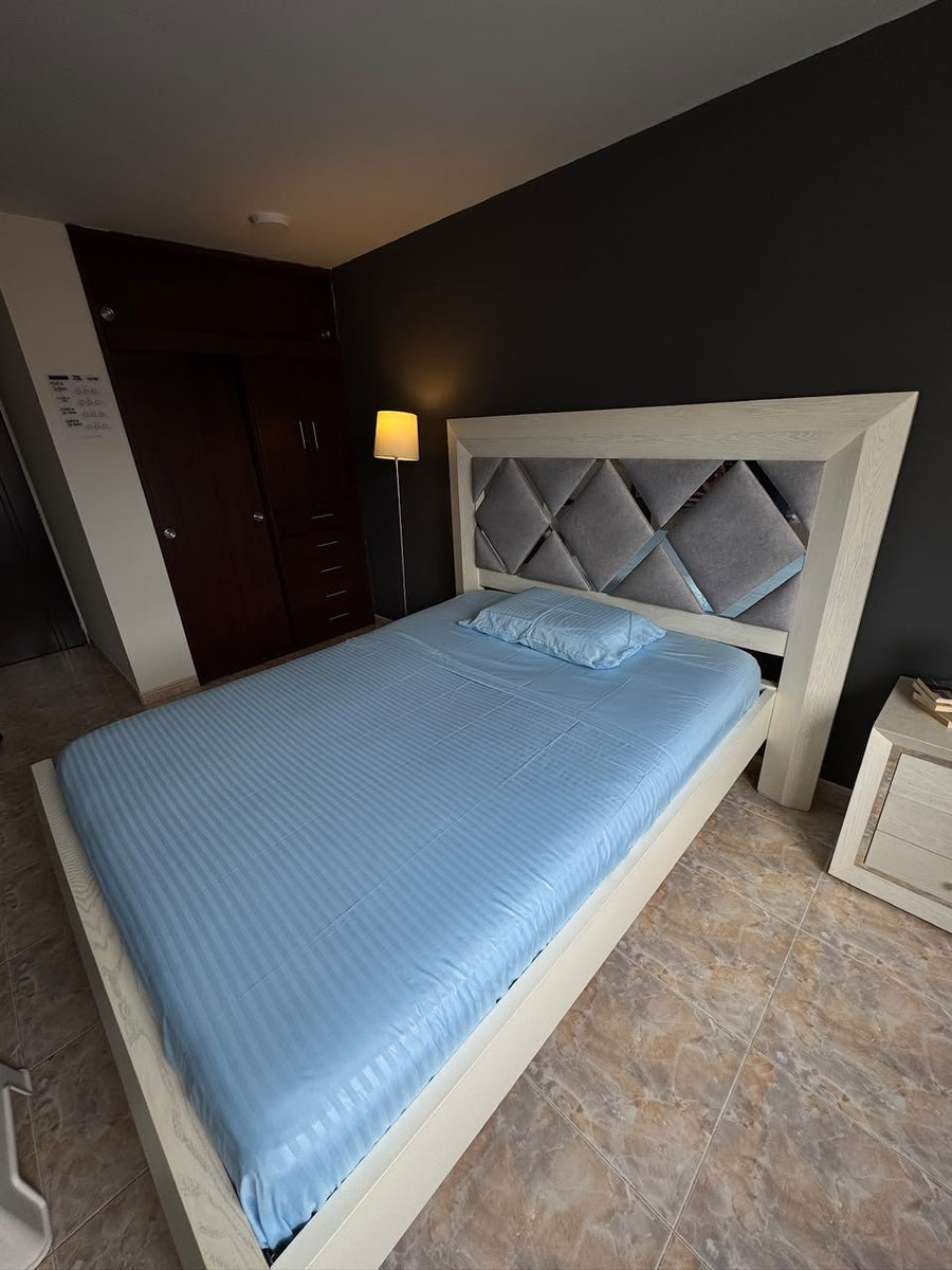 Foto real del juego en color celeste, tendido en una cama