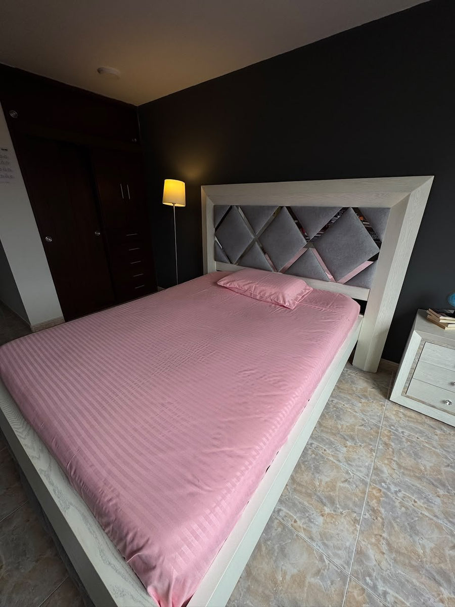 Foto real del juego en color palo rosa, tendido en una cama